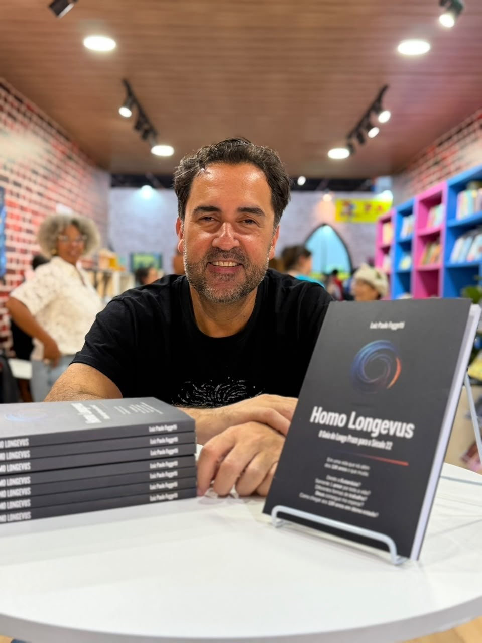 Luiz Paulo Foggetti sorrindo ao lado de exemplares de Homo Longevus